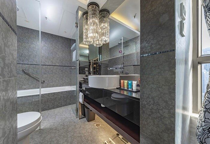 The Mercer Hong Kong gay-friendly hotel bathroom. Bathtub, sink, & chandelier. Upscale design for LGBTQ+ travelers.