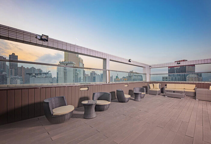 Rooftop lounge at The Mercer Hong Kong, a gay-friendly hotel. Modern outdoor furniture with city skyline views. Perfect for gay travelers.