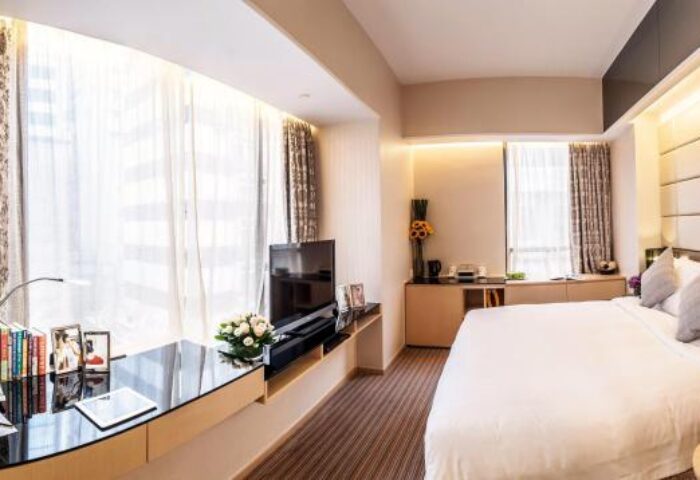 The Mercer Hong Kong gay-friendly hotel room. Modern design with desk, TV, and large window. Luxury accommodations for gay travelers.