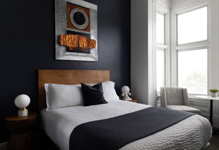 The Metro Hotel bedroom. Gay-friendly hotel room with bed, modern art, and window seat. Comfortable lodging for gay travelers.