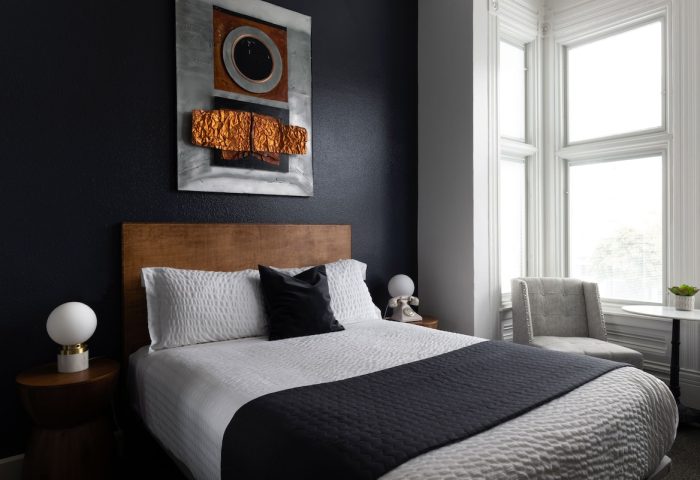 The Metro Hotel bedroom. Gay-friendly hotel room with bed, modern art, and window seat. Comfortable lodging for gay travelers.