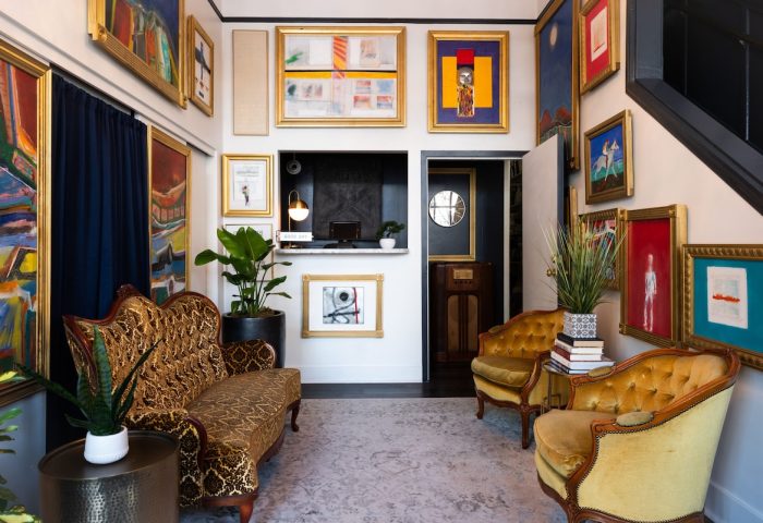 The Metro Hotel's lobby: a gay-friendly hotel. Eclectic art, vintage furniture, and a welcoming reception area create a unique, stylish vibe.