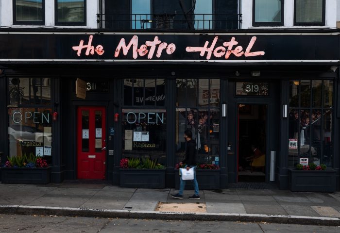 The Metro Hotel, a gay-friendly hotel. Exterior view of the hotel with a neon sign. Great choice for gay men travel.