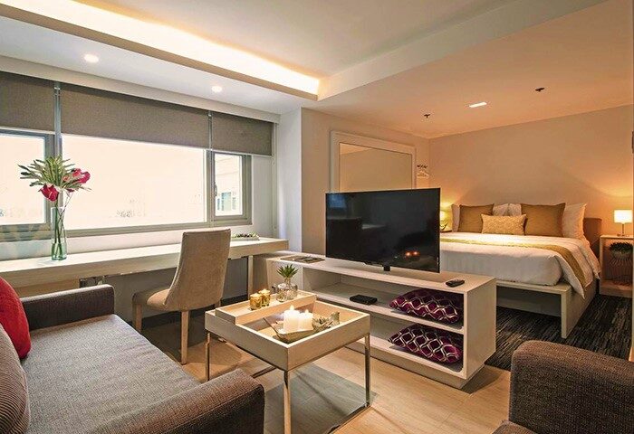 The Mini Suites Eton Tower Makati room. Gay-friendly hotel room with bed, TV, desk, and sofa. Modern interior design for gay travel.