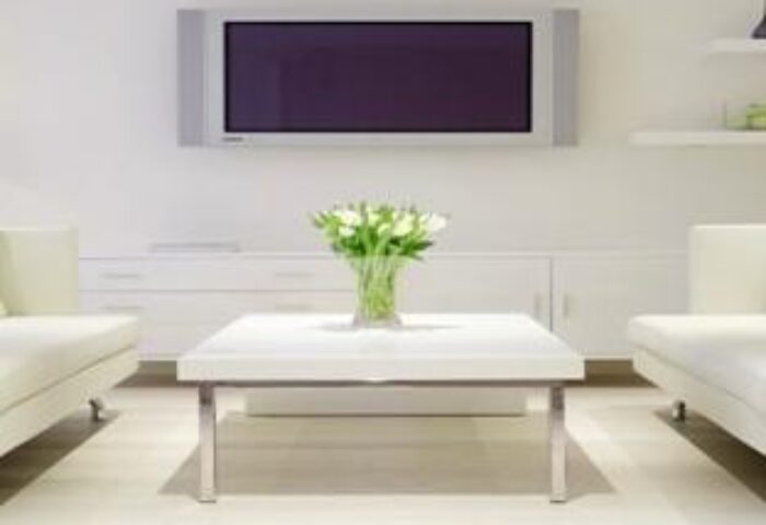 The Morgan Hotel's gay-friendly room: White sofas, table with flowers, and TV. A modern, clean design for gay travelers.
