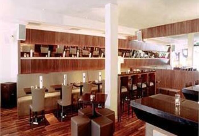 The Morgan Hotel's stylish bar and dining area. Gay-friendly hotel with modern decor, wood paneling, and comfortable seating. Perfect for gay men travel.
