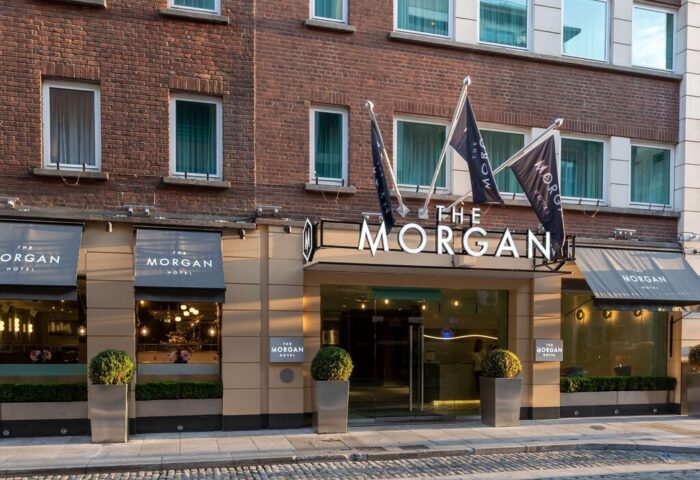 Exterior of The Morgan Hotel, a gay-friendly hotel in Dublin, Ireland. Flags with The Morgan Hotel logo. Modern entrance. Brick facade.
