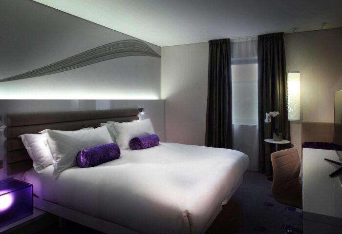 The Morrison, a DoubleTree by Hilton Hotel, gay-friendly. Modern room with king bed, purple accents. Ideal for gay travelers' comfort.
