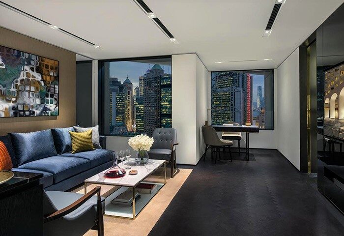 Gay-friendly The Murray, Hong Kong, a Niccolo Hotel suite. Living area with sofa, city views. Luxury gay travel accommodations in Hong Kong.