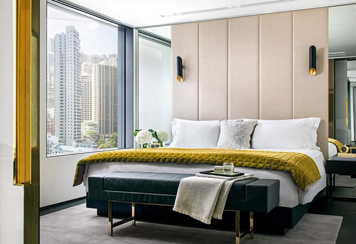 The Murray, Hong Kong, a Niccolo Hotel: Gay-friendly hotel room with a bed, bench, and city view. Luxury travel for gay men in Hong Kong.