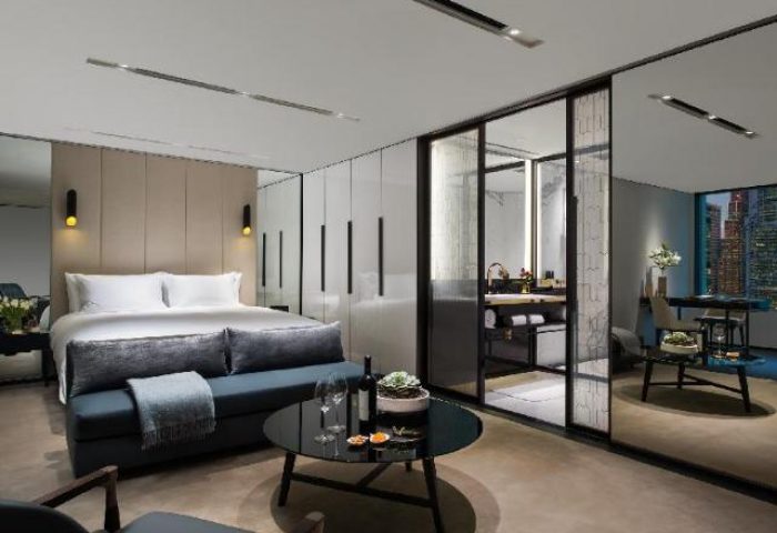 The Murray, Hong Kong, a Niccolo Hotel room. Gay-friendly hotel with a bed, couch, and bathroom. Modern design for gay travel.