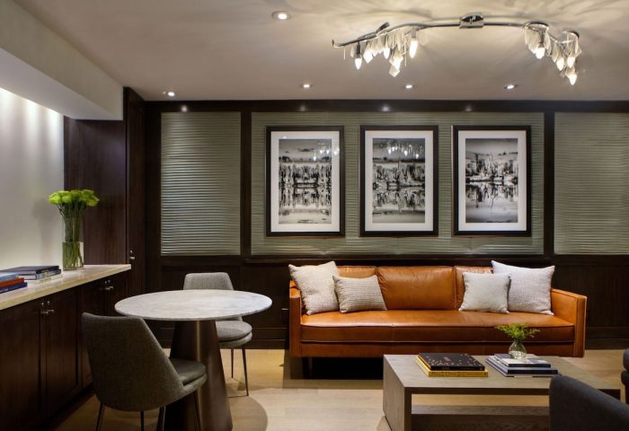 The Muse New York, a gay-friendly hotel. Lounge area with leather couch, table, and art. Perfect for gay travel in NYC.