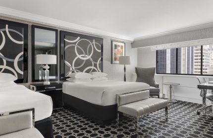 The Muse New York, a gay-friendly hotel. Room with two beds, patterned headboards, city view. Stylish lodging for gay travelers.