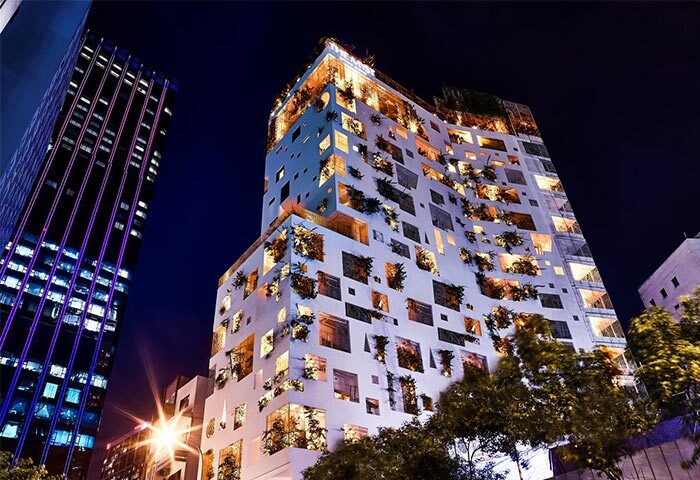 The Myst Dong Khoi at night. Gay-friendly hotel with unique architecture, featuring plants in window boxes. A top destination for gay travel.