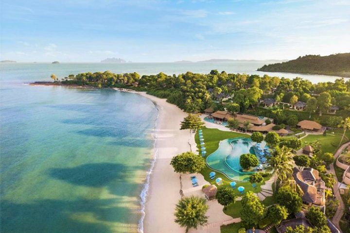 Aerial view of The Naka Island, a Luxury Collection Resort & Spa, Phuket. Gay-friendly hotel with beach, pool, and lush tropical landscape.