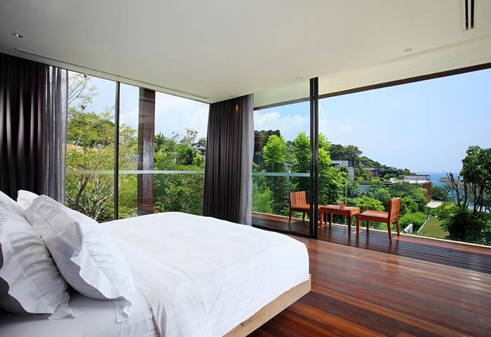 The Naka Phuket Villa, gay-friendly hotel. Bedroom with nature view. Balcony with chairs. Perfect for gay men travel.