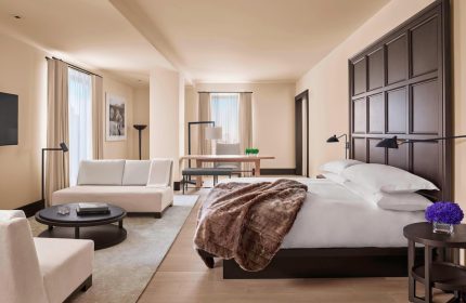 The New York EDITION hotel room. Gay-friendly hotel with bed, couch, and desk. Luxury travel for gay men in NYC. Hotel interior design.