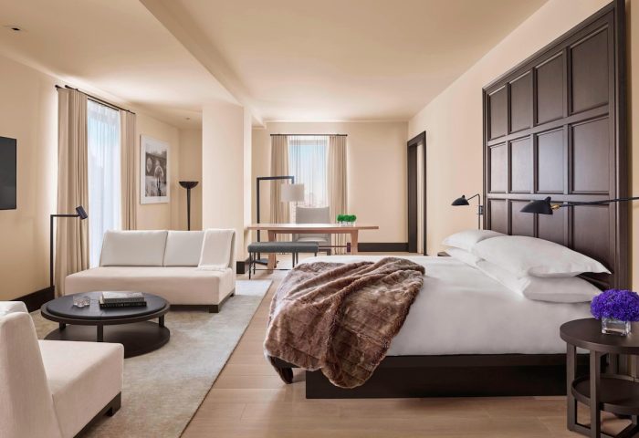 The New York EDITION hotel room. Gay-friendly hotel with bed, couch, and desk. Luxury travel for gay men in NYC. Hotel interior design.