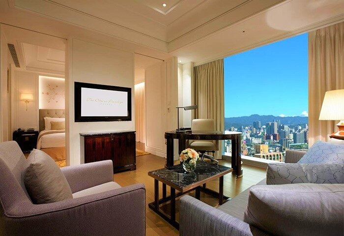 The Okura Prestige Taipei Hotel room. Gay-friendly hotel with city view, desk, and seating area. Modern, luxurious accommodations in Taipei.