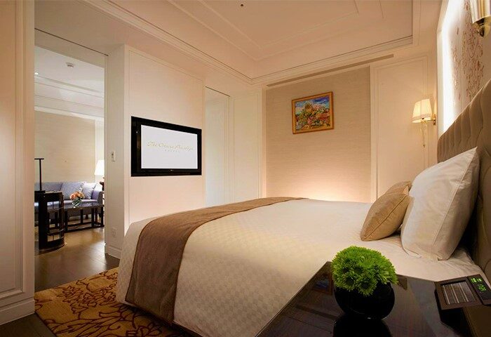 The Okura Prestige Taipei Hotel room. Gay-friendly hotel with bed, TV, and sitting area. Luxury travel for gay men in Taipei.