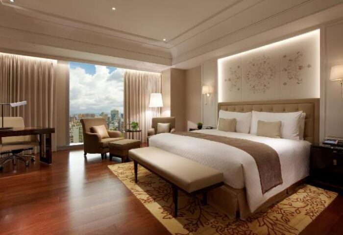 Okura Prestige Taipei Hotel room. Gay-friendly hotel with city view, desk, chairs, and king bed. Luxury Taiwan travel for gay men.