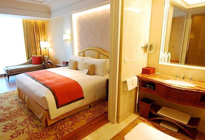 Okura Prestige Taipei Hotel room. Gay-friendly hotel featuring a luxurious bedroom with a king-size bed and an elegant bathroom.