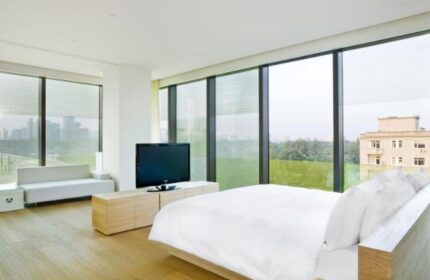 The Opposite House Hotel room. Gay-friendly hotel with a bed, TV, couch, and large windows. Great for gay men's travel.