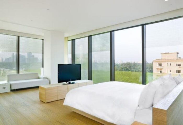 The Opposite House Hotel room. Gay-friendly hotel with a bed, TV, couch, and large windows. Great for gay men's travel.