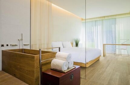 Gay-friendly The Opposite House Hotel room. Wood bathtub, white linens, modern design. Ideal for gay travel in Beijing, China.
