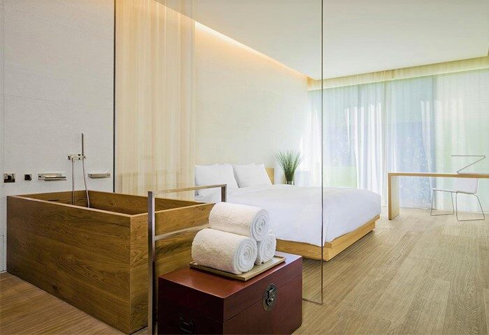Gay-friendly The Opposite House Hotel room. Wood bathtub, white linens, modern design. Ideal for gay travel in Beijing, China.