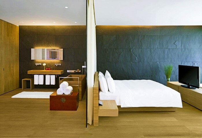 Hotel room at The Opposite House Hotel, a gay-friendly hotel. Modern design with a bed, bathroom, and TV. Perfect for gay travel.