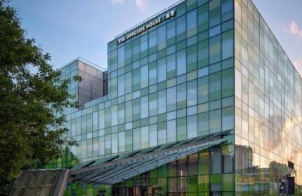 Exterior of The Opposite House Hotel, a gay-friendly hotel with a modern glass facade. A great choice for gay travelers.