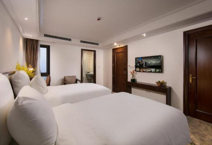 The Oriental Jade Hotel room with two beds, TV, and bathroom. Gay-friendly hotel, perfect for gay men travel.