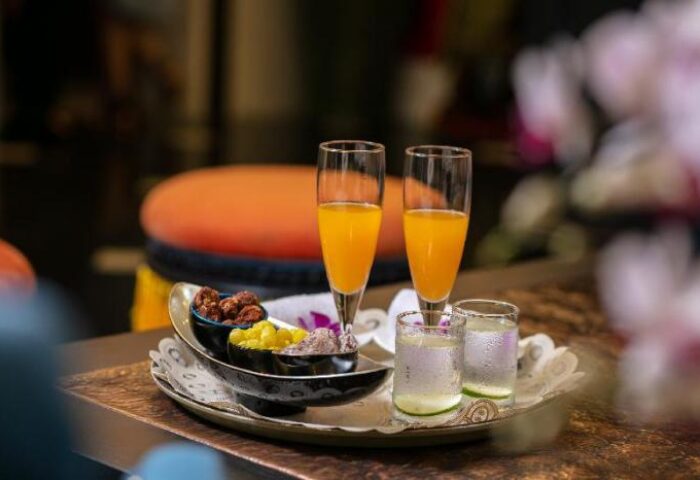 Welcome drinks at The Oriental Jade Hotel, a gay-friendly hotel. Tray with juice, water, and snacks. Gay travel advice.