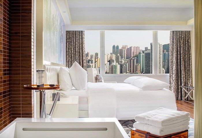 The Park Lane Hong Kong a Pullman Hotel room. Gay-friendly hotel with city view. Modern design, white linens, and upscale amenities.