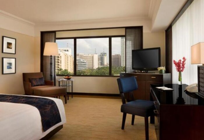 The Peninsula Manila gay-friendly hotel room. City view, TV, desk, and chair. A great choice for gay travelers seeking luxury in Manila.