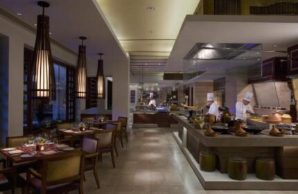 Dining at The Peninsula Manila, a gay-friendly hotel. Restaurant interior with chefs preparing food. Fine dining experience in Makati.