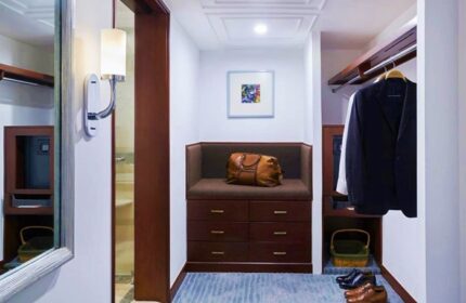 Closet area at The Peninsula Manila, a gay-friendly hotel. Features luggage, drawers, hanging clothes, and shoes. Great for gay travel.