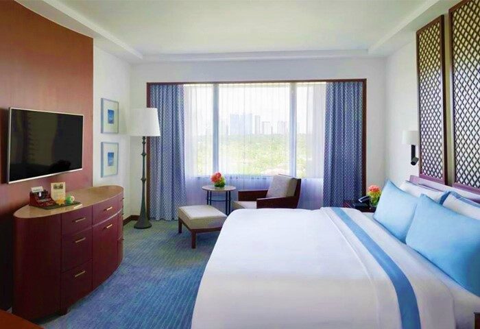 The Peninsula Manila hotel room. Gay-friendly hotel with bed, TV, and city view. Luxury travel for gay men in Manila. Hotel room interior.