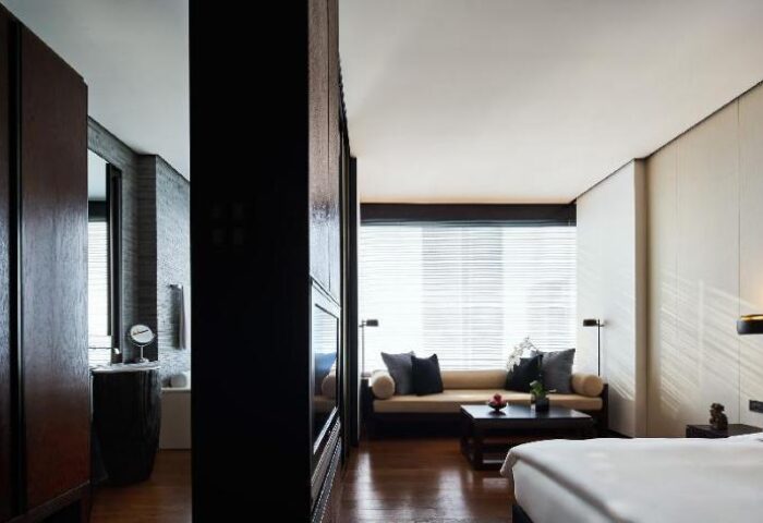 The PuLi Hotel and Spa room. Gay-friendly hotel with modern design, including a sofa, bathroom, and sleek decor. Luxury travel.