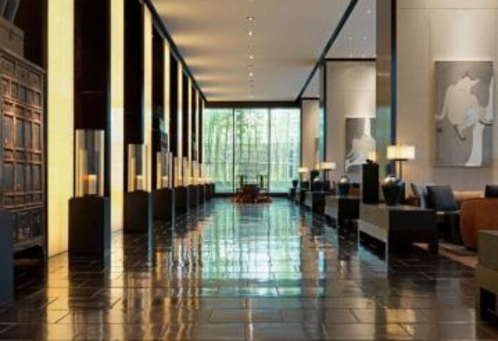 The PuLi Hotel and Spa lobby. Gay-friendly hotel with a long, shiny floor, modern decor, and a view of lush greenery. Chic, stylish design.