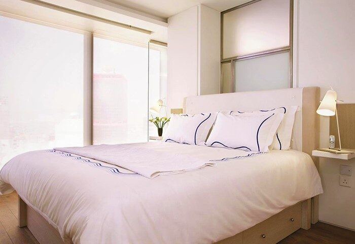 The Putman gay-friendly hotel room. Modern design with white linens, blue accents, and a bright, airy feel. Perfect for gay travel.