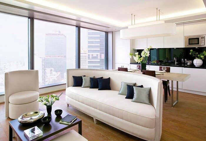 The Putman, a gay-friendly hotel. Modern suite interior with city view, sofa, and dining area. Ideal for gay men travel, luxury and comfort.