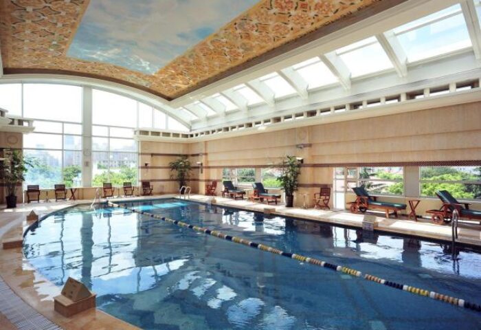 Indoor pool at the gay-friendly Radisson Collection Hotel Xing Guo, Shanghai. Relaxing swimming area with lounge chairs and natural light.