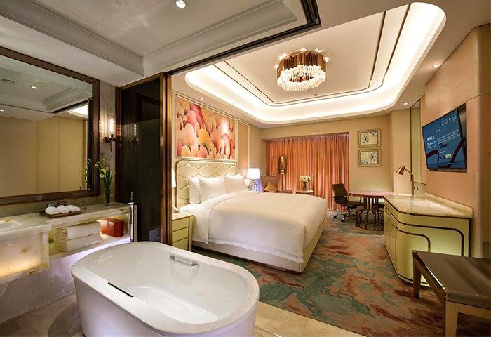 Radisson Collection Hotel Xing Guo Shanghai gay-friendly room. Luxury hotel room with bathtub, bed, desk, and modern decor. Shanghai gay travel.