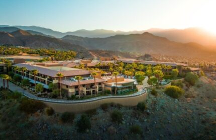 The Ritz-Carlton, Rancho Mirage: Gay-friendly hotel aerial view. Resort with mountains, palm trees, and desert landscape at sunset.
