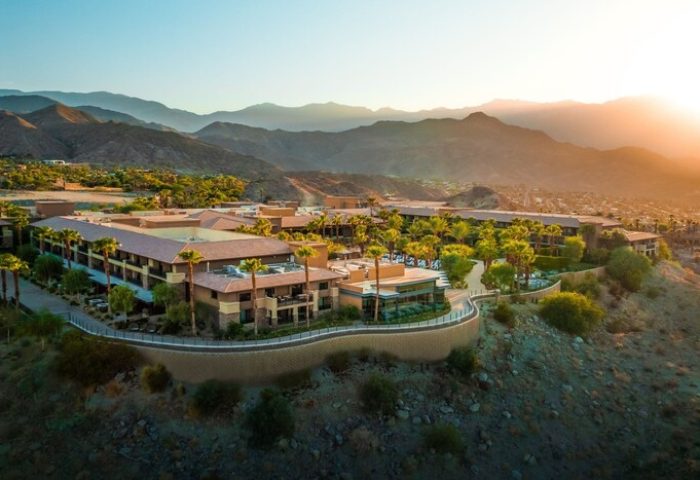 The Ritz-Carlton, Rancho Mirage: Gay-friendly hotel aerial view. Resort with mountains, palm trees, and desert landscape at sunset.