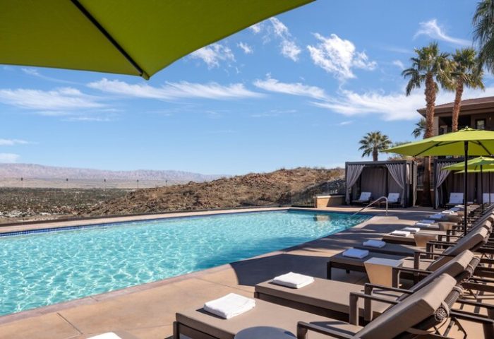 Pool view at The Ritz-Carlton, Rancho Mirage, a gay-friendly hotel. Lounge chairs, umbrellas, and cabanas offer relaxation with desert views.