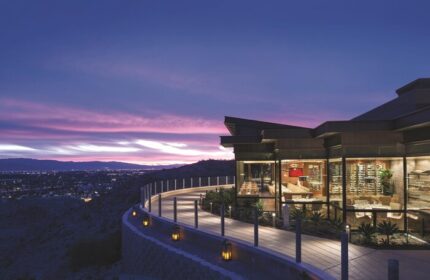 The Ritz-Carlton, Rancho Mirage: A gay-friendly hotel at dusk. View of the restaurant, walkway, and city lights. Luxury gay travel.