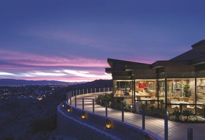 The Ritz-Carlton, Rancho Mirage: A gay-friendly hotel at dusk. View of the restaurant, walkway, and city lights. Luxury gay travel.